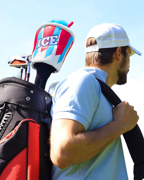 Golfer carrying bag with Ice Slushie Cup Golf Driver Cover 460cc Head Cover For Golf Clubs, blue red theme, outdoor setting.