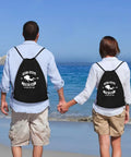 Couple at the beach wearing Scuba Steve Scuba Squa Drawstring Gym Bag With Water Resistant 210D Polyester Lightweight Durable Sport Sack