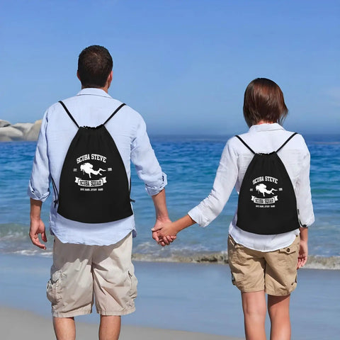 Couple at the beach wearing Scuba Steve Scuba Squa Drawstring Gym Bag With Water Resistant 210D Polyester Lightweight Durable Sport Sack