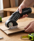 Lightweight Cordless Electric Scissors With Safety Lock For Easy Cutting Cardboard Fabric Leather Rope Plastic Carpet Perfect For Home DIY Craft Projects And General Household Tasks With Fast Usb Charging And Dual Blades Included For Efficient Workflow cutting through cardboard on a wooden table.