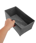 Hand holding a gray fabric drawer divider from the Super Sturdy Foldable Drawer Clothing Organizer Set Eight Piece Gray Fabric Wardrobe Dividers.
