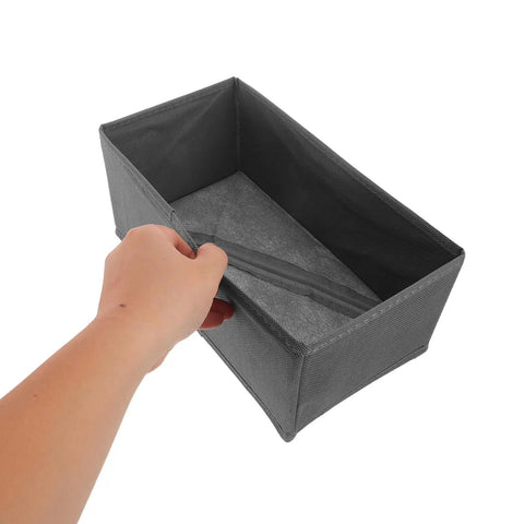 Hand holding a gray fabric drawer divider from the Super Sturdy Foldable Drawer Clothing Organizer Set Eight Piece Gray Fabric Wardrobe Dividers.