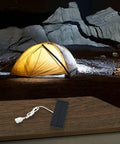 Monocrystalline 2W 5V Solar Panel Charger With USB Output for mobile devices on a table, lit tent in background