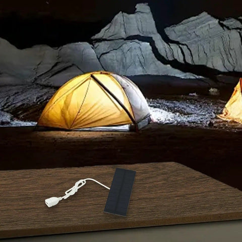 Monocrystalline 2W 5V Solar Panel Charger With USB Output for mobile devices on a table, lit tent in background