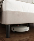 Super Soft King Velvet Bed Frame With Channel Tufted Headboard In Classic Beige with a robot vacuum underneath for easy cleaning.