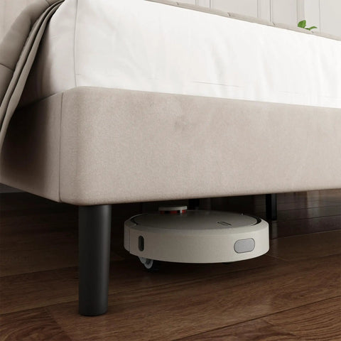 Super Soft King Velvet Bed Frame With Channel Tufted Headboard In Classic Beige with a robot vacuum underneath for easy cleaning.