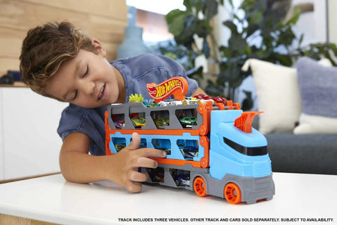Child playing with Speedway Hauler Storage Carrier With Three 1 To 64 Scale Cars And Convertible Six Foot Drag Race Track