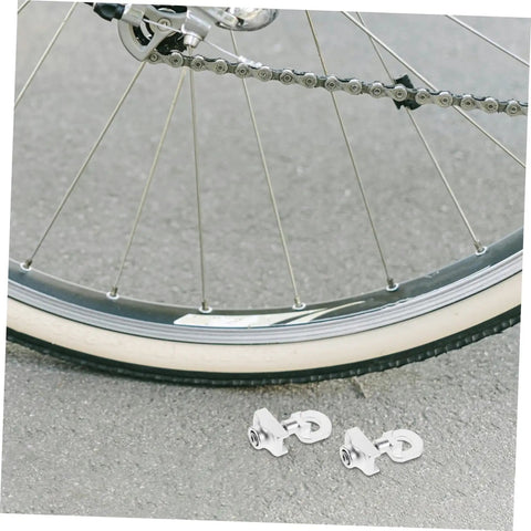 Adjustable Aluminum Alloy Bike Chain Tensioner Tool 2 Piece Set For Folding Bikes next to a bicycle wheel on pavement.