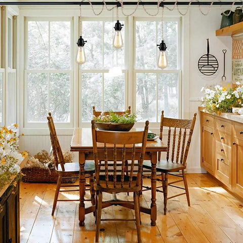 Three Light Hemp Rope Plug In Pendant Light With Woven Rattan Shade And Adjustable Cord Switch For Rustic Farmhouse Decor hanging above a wooden dining table.