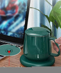 Smart Coffee Mug Warmer And Versatile Candle Warmer Pad For Desk with green finish, heating cup on desk beside laptop.