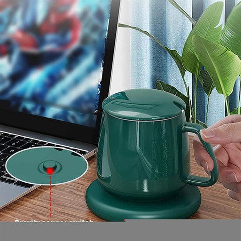 Smart Coffee Mug Warmer And Versatile Candle Warmer Pad For Desk with green finish, heating cup on desk beside laptop.