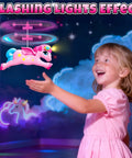 Girl playing with Magical Flying Unicorn Toy For Girls With LED Lights Fairy Flying Ball Helicopter Drone, lit with a night glow.
