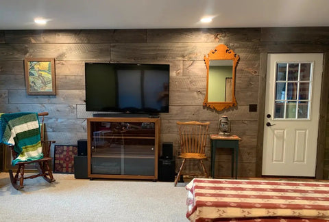 Slick Water Based Aging Wood Stain Yields Authentic Driftwood Gray Finish on interior wall with TV and rustic decor.