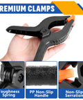 Ten-pack 6-inch black plastic spring clamps with orange tips for crafts, photography, and backdrops.