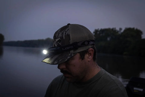 Person using Hades Headlamp Go-To 1000 Lumen Rechargeable LED Weather Ready IPX4 during twilight near a river.