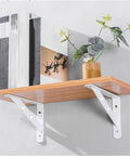 Heavy Duty Triangular Corner Shelf Brackets 2 Pack White Steel Wall Mounts For Scaffold Boards supporting wooden shelf with decor.