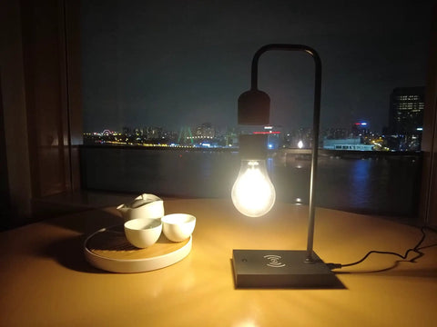 Dope Magnetic Levitating Lamp With Floating LED Bulb Wireless Charging Desk Light on table, city view background