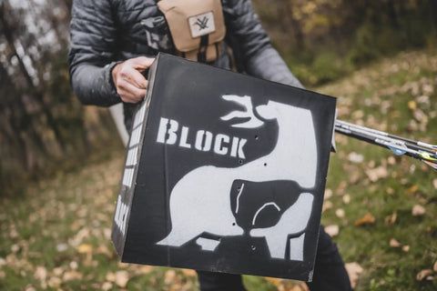 Person holding 3D Archery Target 48 Inch Tall With Replaceable Insert, weather-resistant high density foam, six-sided design, outdoors.