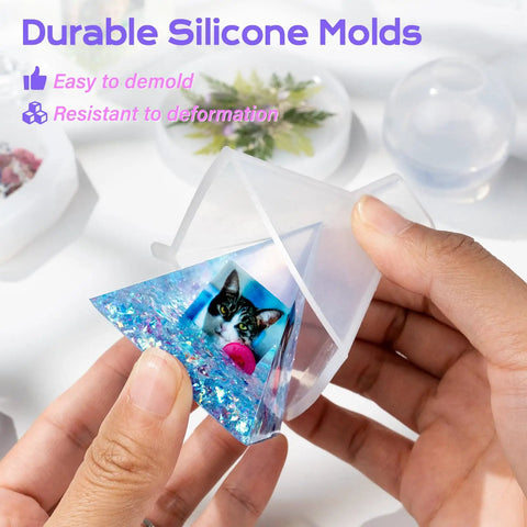 Person holding pyramid silicone mold with resin featuring cat design from Epoxy Resin Kit With Molds For Newbies 18 Oz Clear Hard Resin Starter Casting Arts And Crafts DIY Gift Set With Silicone Molds, Mat, Glitter, Foil Paper, Measuring Cups, Sticks And Gloves