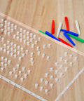 Clear Acrylic Cribbage Board Template Kit With Twelve Colorful Counting Pegs For Game Night Essentials showing pegs on wood surface.