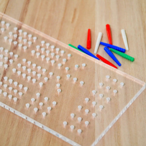 Clear Acrylic Cribbage Board Template Kit With Twelve Colorful Counting Pegs For Game Night Essentials showing pegs on wood surface.
