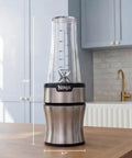 Heavy Duty Personal Blender Featuring 900W Push To Blend Motor And Pro Extractor Blades Crushing Ice For Nutrient Dense Smoothies Including Three Grab And Go 20 Oz Serveware Cups In Classic Silver, measuring 13.8" height and 4.7" width.