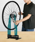 Person adjusting bike wheel on Pro Grade Bicycle Wheel Truing Stand With Adjustable Width And Dual 360 Degree Rotating Adjustments