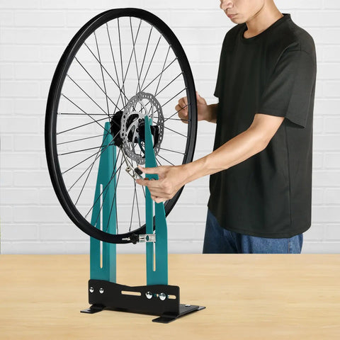 Person adjusting bike wheel on Pro Grade Bicycle Wheel Truing Stand With Adjustable Width And Dual 360 Degree Rotating Adjustments