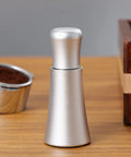 Espresso Distribution Tool With 10 Needle 0.35mm Precision Stirrer Matte Black Finish on a wooden table next to espresso cup