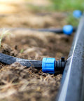 Drip Irrigation Barbed Locking Fittings With Washers For 16mm Drip Tape Tubing Sprinkler System Easy Install Durable PE Plastic Pack Of 20 Blue Great For Gardeners And DIY Sprinkler Setups shown installed in soil