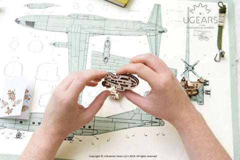 Hands assembling Four Pack Wooden 3D Aircraft Puzzle Kit For Kids 5 Plus Buildable Mechanical Models Helicopter And Hydroplane