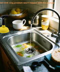 Compact Mini Sink Drain Plunger With Short Handle And Heavy Duty Rubber Cup by a kitchen sink with water and vegetables