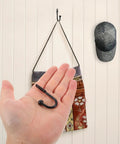 Grab These Bad Boys 12 Pack Black Mini Metal Wall Mount Coat Hooks For Doors And Walls Vintage Style held in hand with wall mounted cap.