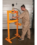 Worker operating Beefy 12 Ton Hydraulic Shop Press With Adjustable Height Remote Cylinder And Pressure Gauge For Heavy Duty Auto And Metalworking Projects Ideal For Bearing Presses Bushing Installations And Frame Repairs.