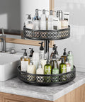 Two-tier black metal 12-inch lazy Susan turntable on kitchen counter, filled with lotion and soap bottles.
