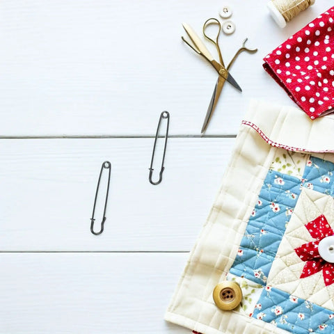 Luxurious Heavy Duty Safety Pins For Women Thick Iron Sweater Clips on a quilted surface with sewing tools.