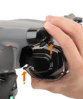 Person attaching Anti Scratch Gimbal Lens Cap For Air 3S Drone Protective Cover Durable PC Material Easy Snap On to drone