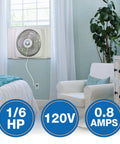 16-Inch Window Fan With Storm Guard installed in bedroom window, showing impact-resistant plastic housing, white color, and power details.