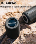 Compact Waterproof Portable Bluetooth Speaker That Goes Hard With Deep Bass, Dual Pairing, FM Radio, USB And AUX Input on rocks