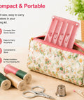 Pink seam guide for sewing machine, a universal quilting accessory, inside floral sewing kit with threads and scissors nearby.