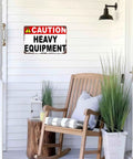 Caution Heavy Equipment Safety Sign With Funny Aluminum Wall Decor, 8x12 Inch, displayed on white porch wall