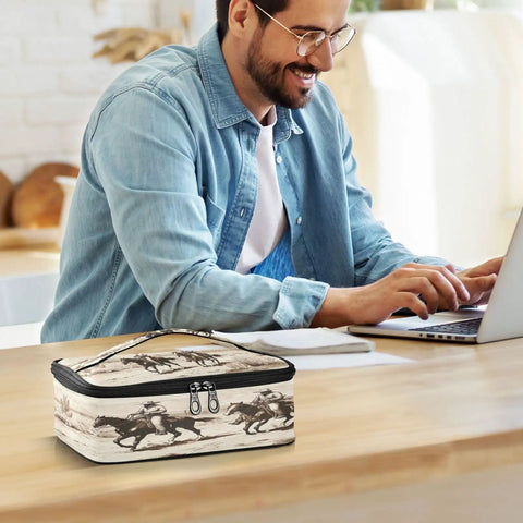 Smiling man with a Desert Cowboys Insulated Lunch Bag With Leakproof No Spill Design on a desk next to him.