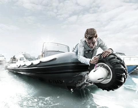 Person adjusting a motor on an inflatable boat on water