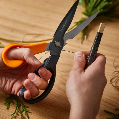 All In One Garden Tool 7-In-1 Pruning Shears For Plant Care With Titanium Knife in use cutting wire on wooden table