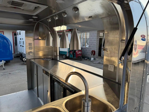 Interior view of Rock Solid Heavy Duty Mobile Coffee Concession Cart With Spacious Storage Compartments showing stainless steel surfaces and lighting.
