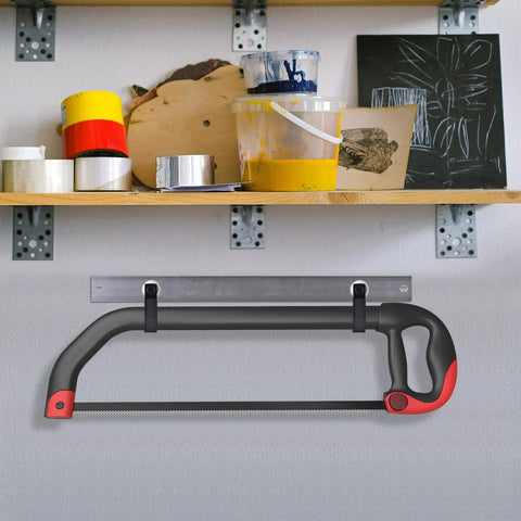 Hacksaw with black and red handle mounted on a wall holder with shelf above containing paint and art supplies.