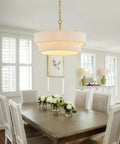 Hand Woven Rattan Chandelier Serving Real Boho Vibes And Adjustable Coastal Design above a dining table with flowers.
