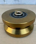 Badass 4 Inch Solid Gate Roller Wheel With Dual Bearing V Groove, Zinc Plated Gold Finish. Side view showing dual bearing.