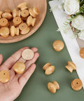 Pack Of Fifty Unfinished Wood Drawer Knobs In Classic Mushroom Shape One Inch Cabinet Handles on a hand and plate.