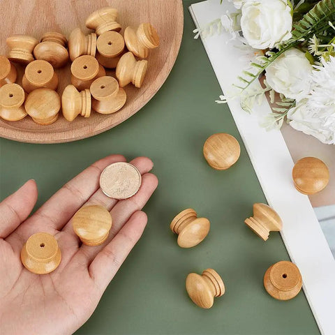 Pack Of Fifty Unfinished Wood Drawer Knobs In Classic Mushroom Shape One Inch Cabinet Handles on a hand and plate.